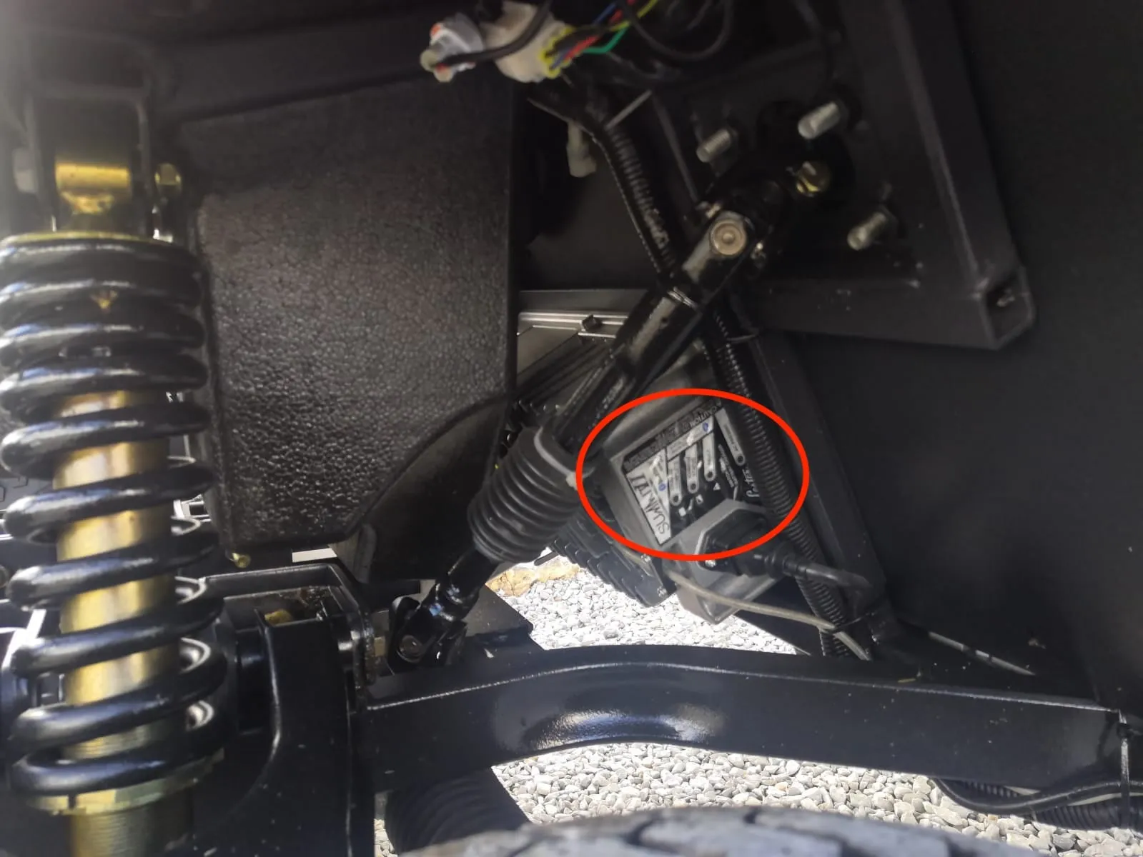Parte inferior del carrito de golf detrás de la rueda delantera, con el cargador marcado