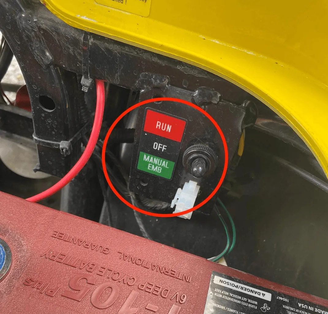 Close-up of the switch under the seat with the positions RUN, OFF and MANUAL EMB