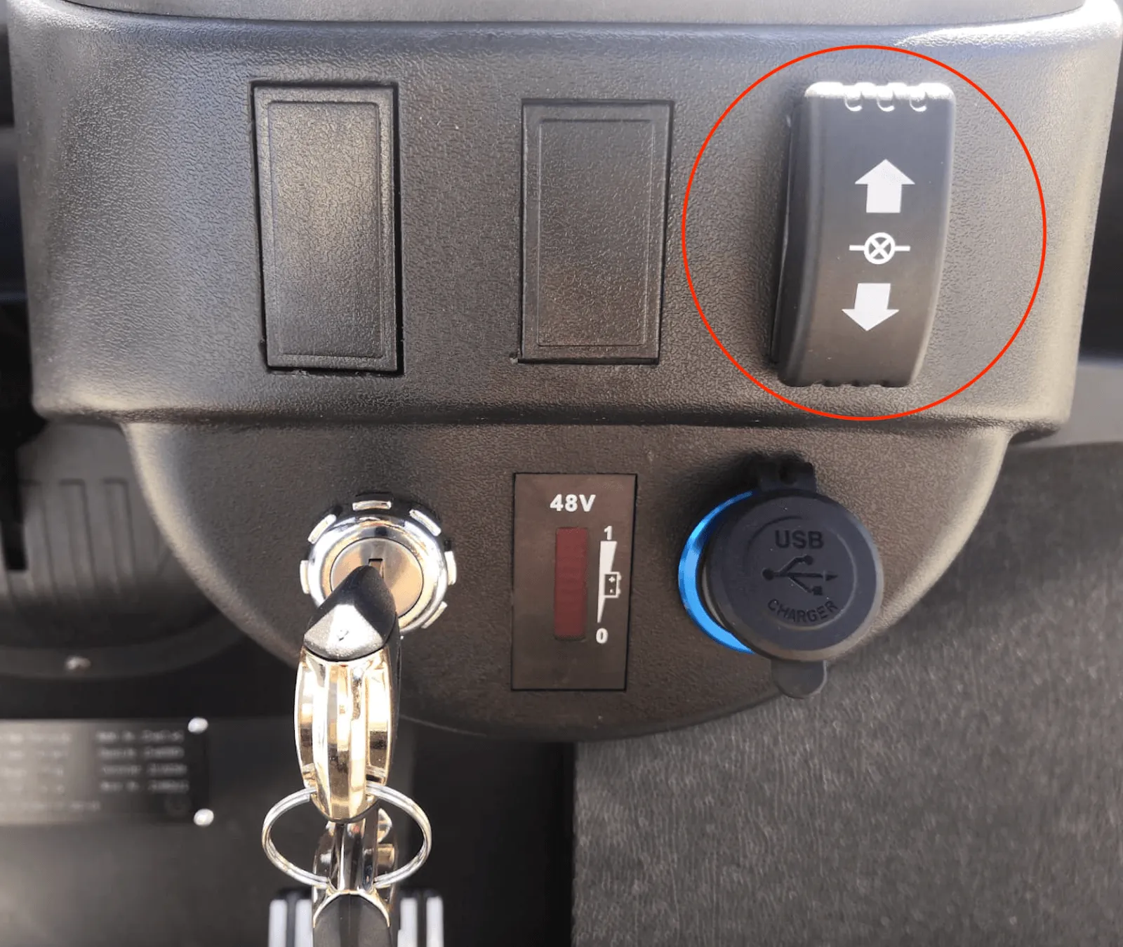 Dashboard with the key ignition, battery meter and USB charger, with the direction switch circled