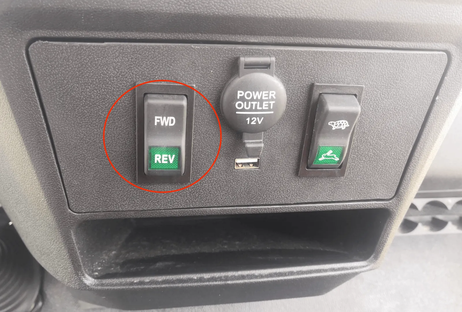 Dashboard panel with the FWD / REV switch circled