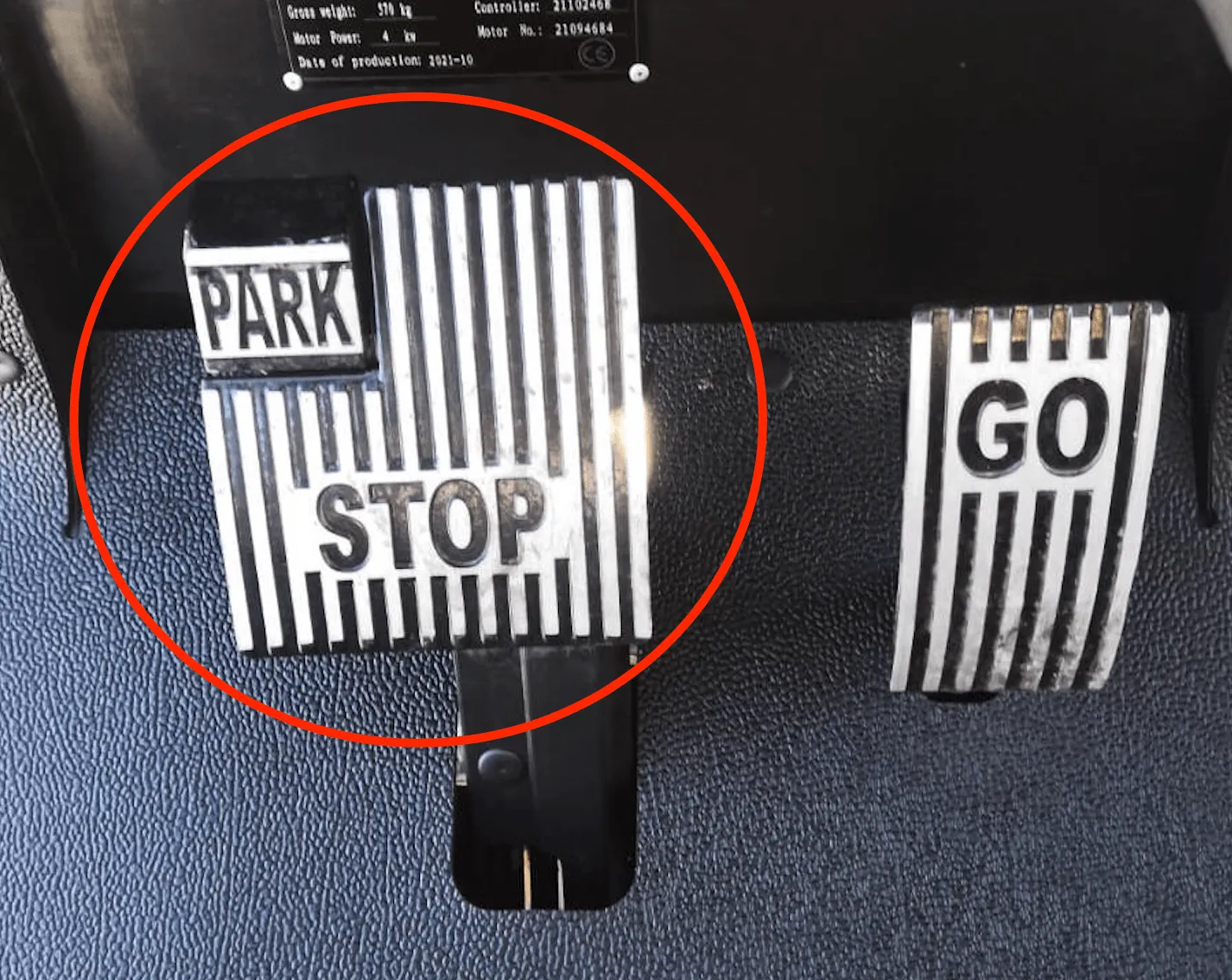 Pedals: the STOP pedal with the PARK brake engaged, circled, next to the GO pedal